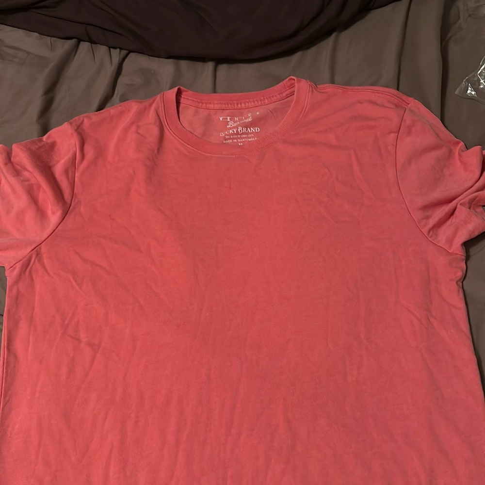 New salmon Lucky Brand Medium t shirt. Never been worn and the tag is still on.